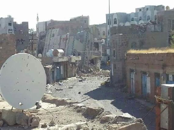 Damaged residential block with collapsed building on its side in Taiz
